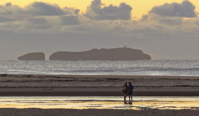 A couple on the shores of Moonee Creek in Moonee Beach Nature Reserve. Photo: Rob Clear &copy; OEH