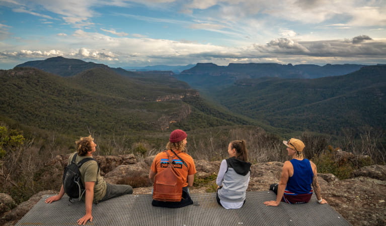 Four walkers take a rest on a viewing platform and look out at the Bundawang Ranges. Photo: John Spencer &copy; DPE