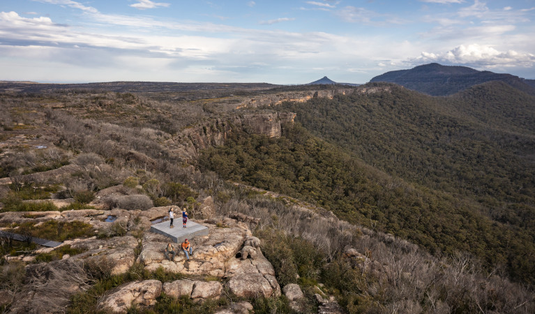 Hikers stop on a viewing platform on a mountain ridge, with view of Clyde Gorge below. Photo: John Spencer &copy DPE