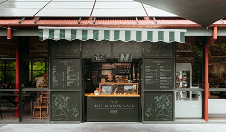 Exterior counter of The Burrow Cafe, with chalk menus and a staff member ready to take your order. The indoor area is also shown (left), Morton National Park. Credit and &copy;: Lily Crouch
