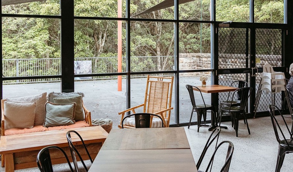 Inside the light-filled Burrow Cafe, with view out to the surrounding bush, Morton National Park. Credit and &copy; Lily Crouch