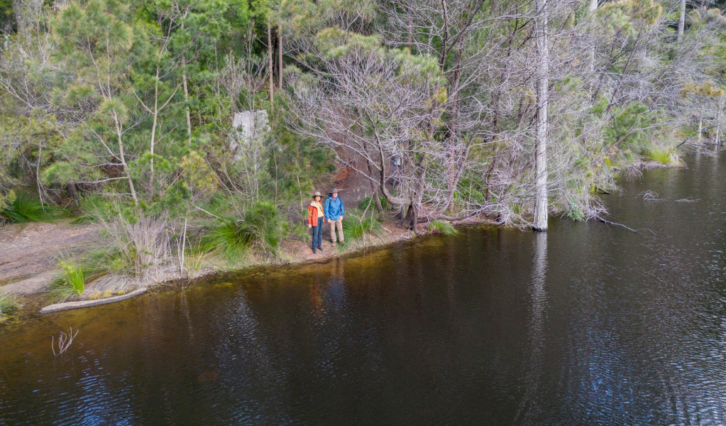 2 bushwalkers on the edge of Rayners Dam in Mount Jerusalem National Park. Credit: John Spencer &copy; DPE 