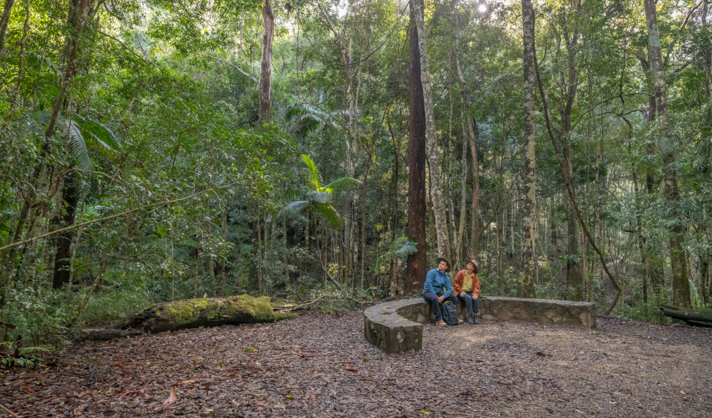 Bushwalkers resting on stone seating near Unicorn Falls, Mount Jerusalem National Park. Credit: John Spencer &copy; DPE 