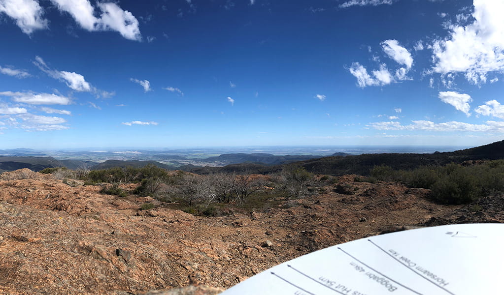 Wide view of distant plains, ridges and valleys from Bundabulla lookout, with a park information panel in the foreground. Photo &copy; Jessica Stokes