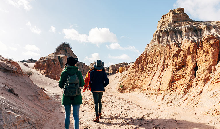 2 girls walk past sand-sculpted formations, Walls of China, Mungo National Park. Photo: &copy; Melissa Findley