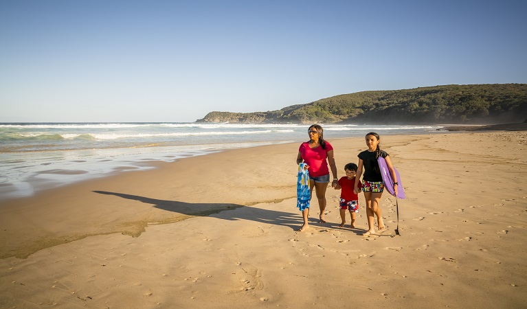 Family walking along Frazer beach, Munmorah State Conservation Area. Photo: John Spencer/OEH