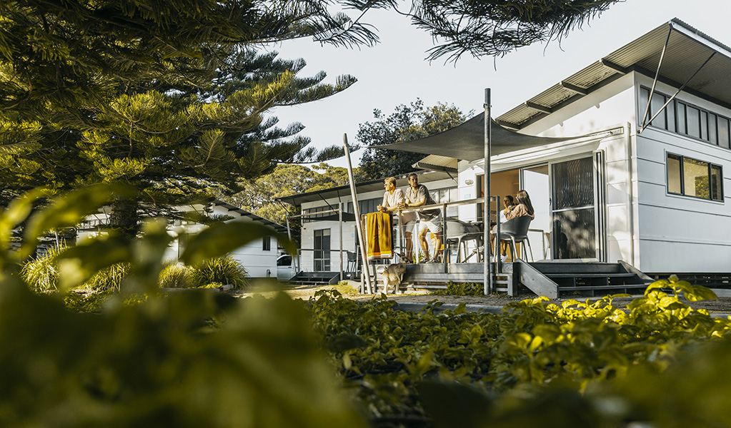 Family enjoying the balcony of one of the cabins in the NRMA Murramarang Beachfront Holiday Resort in Murramarang National Park. Photo: NRMA Parks and Resorts &copy; NRMA Parks and Resorts 