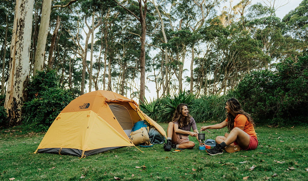 2 campers making coffee outside their tent at Depot Beach campground, Murramarang National Park. Photo: Remy Brand &copy; Remy Brand