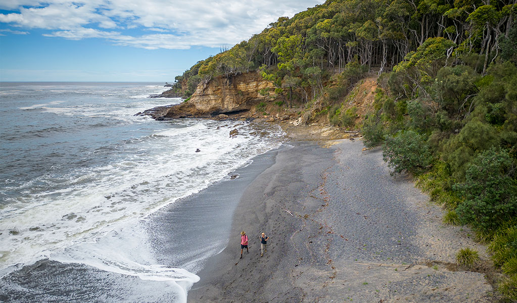 Aerial view of 2 people walking along Dark Beach in Murramarang National Park. Credit: John Spencer &copy; DPE