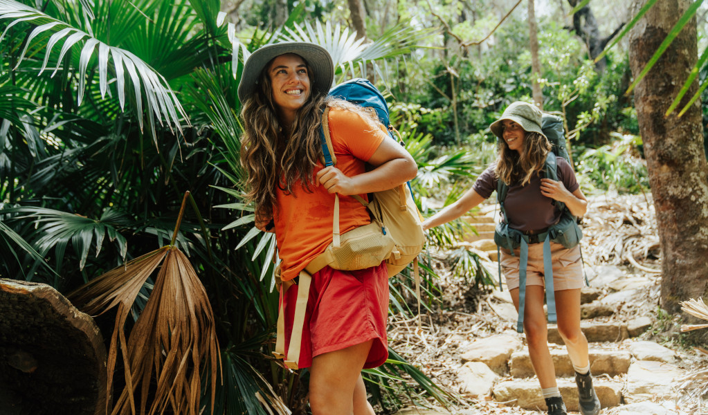 2 bushwalkers descending stairs surrounded by forest on Murramarang South Coast Walk. Credit: Remy Brand © Remy Brand