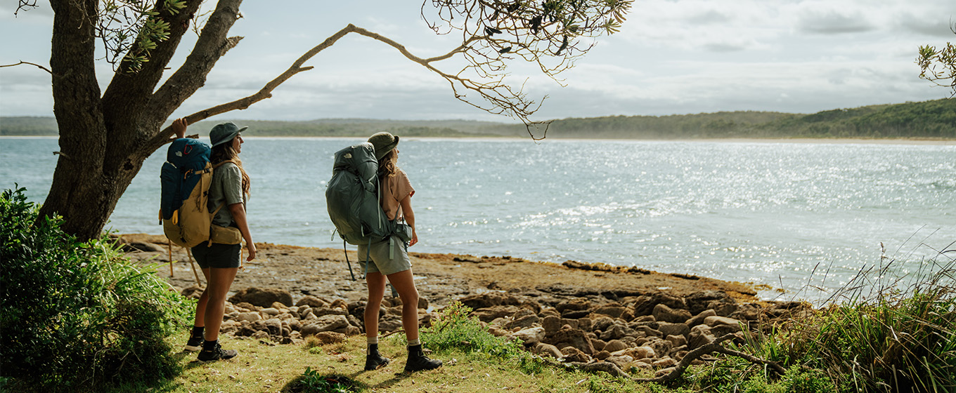 2 walkers admiring the coastal view from Calm Corner, North Durras Beach on the Murramarang South Coast Walk. Credit: Remy Brand © Remy Brand