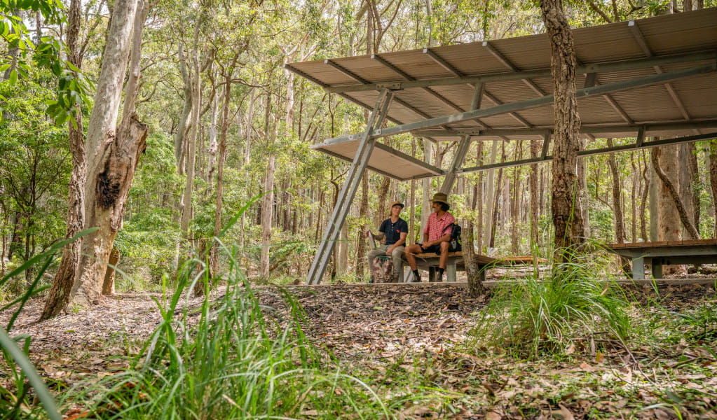 2 campers sitting under the picnic shelter at Oaky Beach campground. Credit: John Spencer &copy; DPE