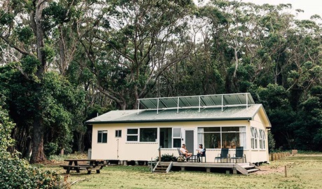 A couple on the deck at Jacks Shack, Pebbly Beach Shacks, Murramarang National Park. Photo: Melissa Findley/OEH.