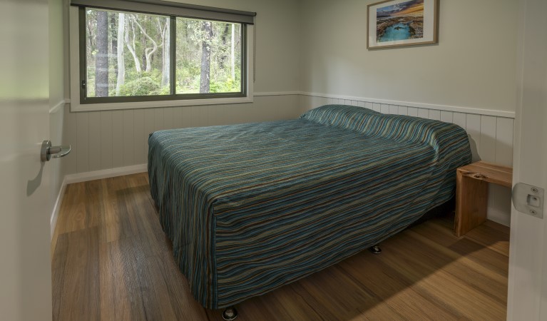 A bedroom with queen bed in Pebbly Beach shacks, Murramarang National Park. Photo: John Spencer &copy; DPIE