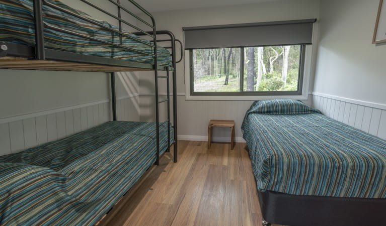 A bedroom with single and bunk bed at Pebbly Beach shacks in Murramarang National Park. Photo: John Spencer &copy; DPIE