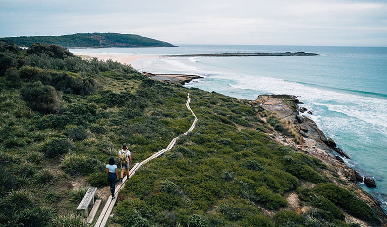 Aerial view of couple walking towards Pretty Beach and Snapper Point, Murramarang National Park. Photo &copy; Melissa Findley