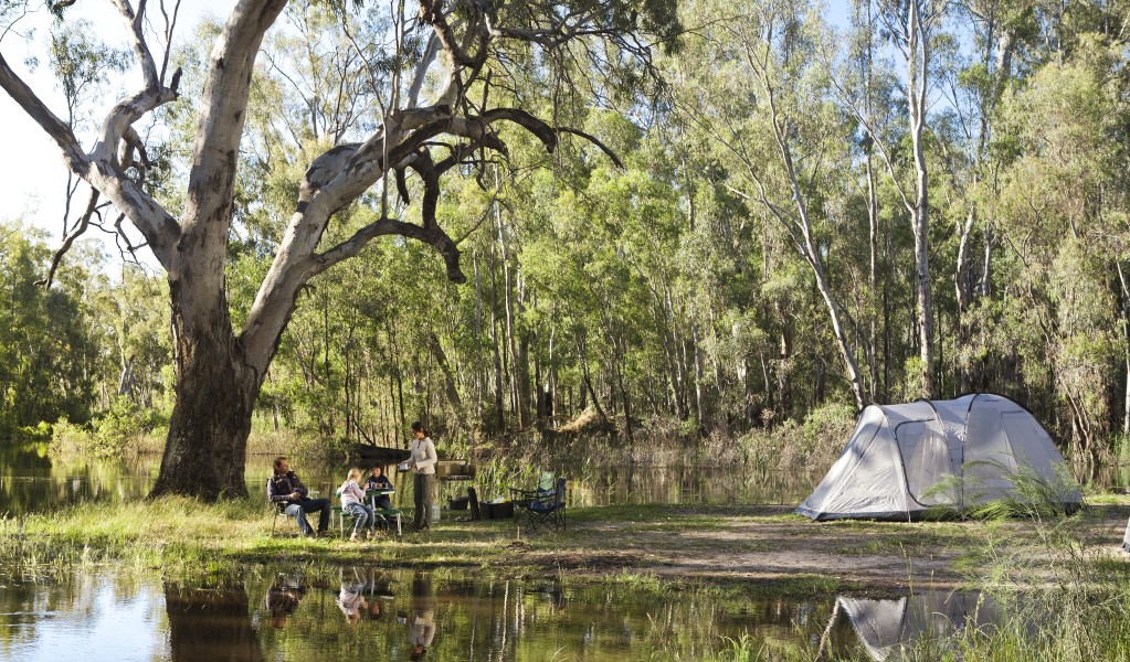 A group of campers sitting next to their tent by the river at Gulpa campgrounds in Murray Valley National Park. Photo: David Finnegan &copy; OEH