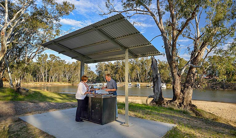 Two people at a barbecue shelter at Ski Beach picnic area, Murray Valley National Park. Photo: Gavin Hansford &copy; OEH