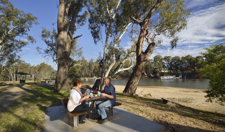 Two people at a picnic table at Ski Beach picnic area next to Murray River in Murray Valley Regional Park. Photo: Gavin Hansford &copy; OEH