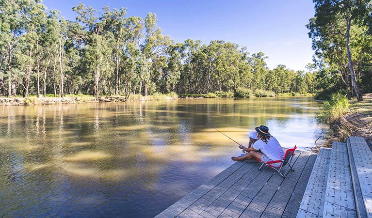 Father and daughter fishing from a deck, Swifts Creek campground, Murray River National Park. Photo: B Ferguson/OEH