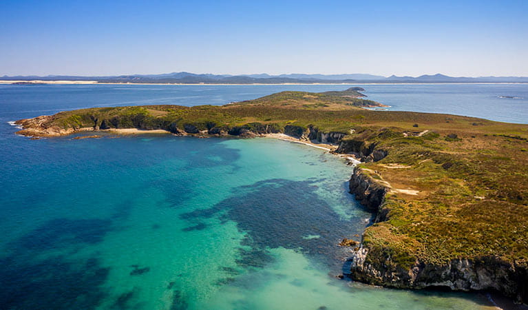 Aerial view of Broughton Island coastline showing Coal Shaft Bay lookout, with the NSW mainland in the background. Photo: John Spencer &copy; DPIE