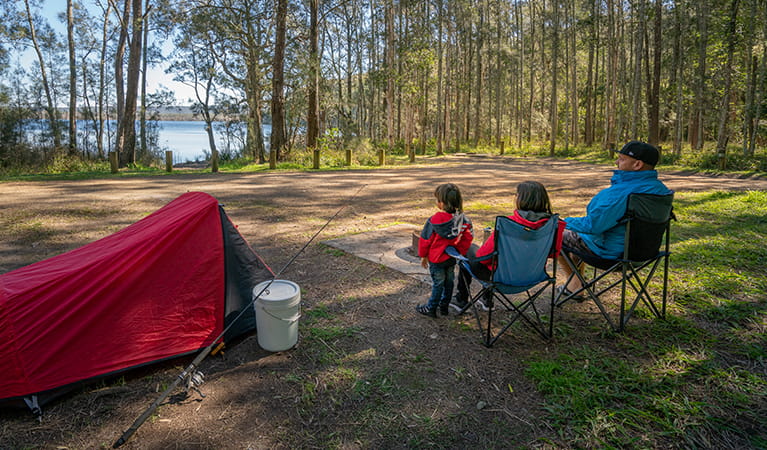 Family watching the lake by their tent at Bungarie Bay campground. Photo: John Spencer/OEH