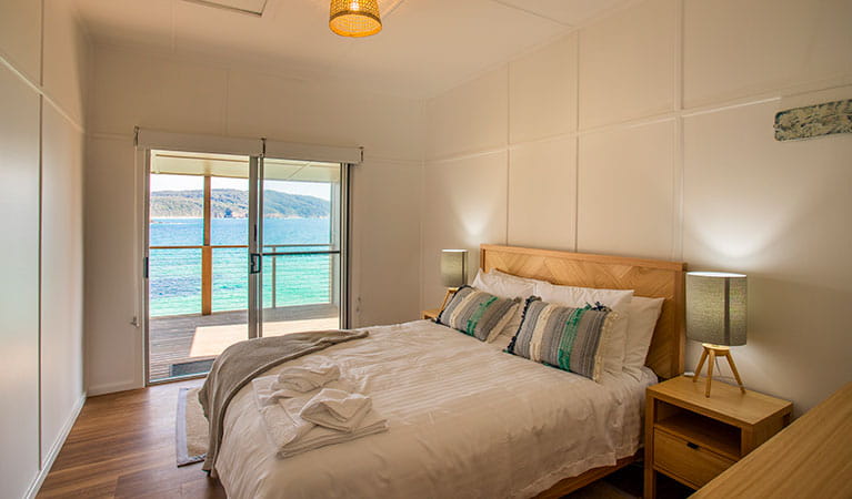  A bedroom with queen bed and ocean views in Davies Cottage. Photo: John Spencer &copy; DPIE