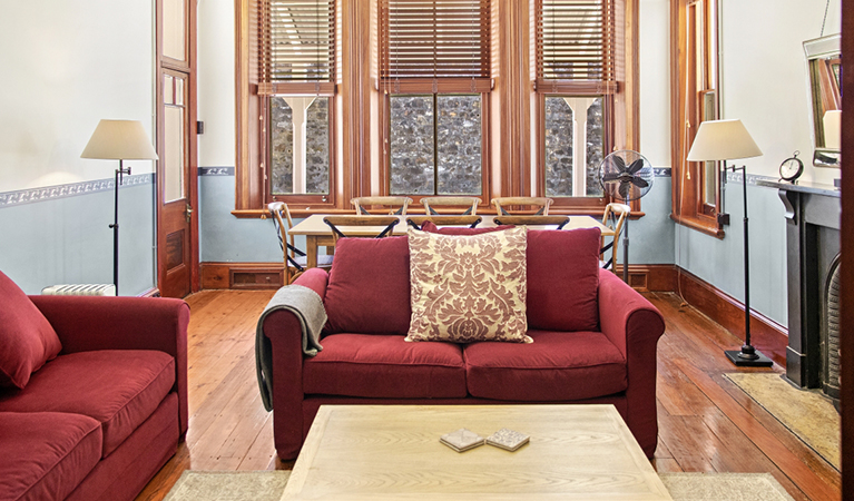 Living room in Head Keeper's cottage with lounges and dining table. Photo: Seal Rocks Lighthouse Cottages