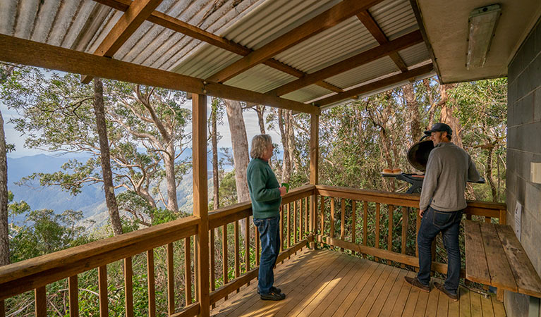 Friends barbecuing food on the balcony of The Chalet. Photo: John Spencer &copy; DPIE