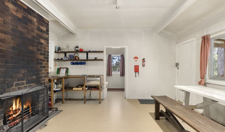 The interior of Toms Cabin with table, benches, fireplace and gas kitchen in New England National Park. Photo:  Mitchell Franzi &copy; DPIE