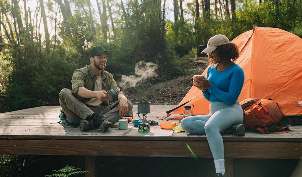 Walkers enjoying tea on the hardwood tent platform at Yelgun Kyoomgun campground. Credit: Remy Brand/DCCEEW &copy; Remy Brand