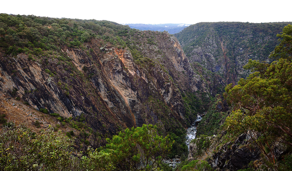 Photo credit: In a rugged and rocky terrain, a river cascades down rock shelves as it courses through a steep gorge. Photo credit: Rob Cleary &copy; DPIE