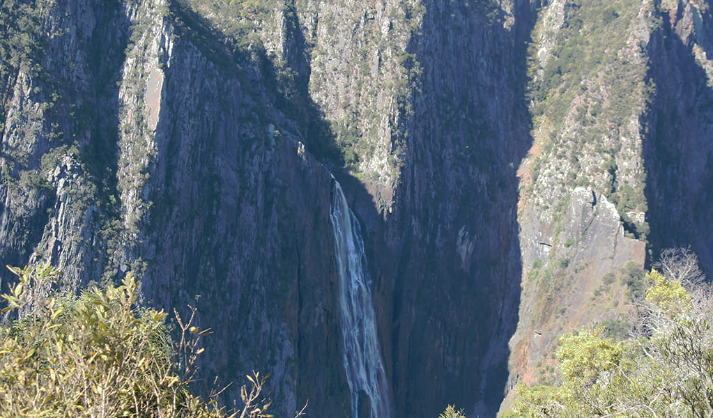 View across a valley to a steep cliff face and waterfall in Oxley WIld Rivers National Park.  Photo &copy; Jessica Stokes