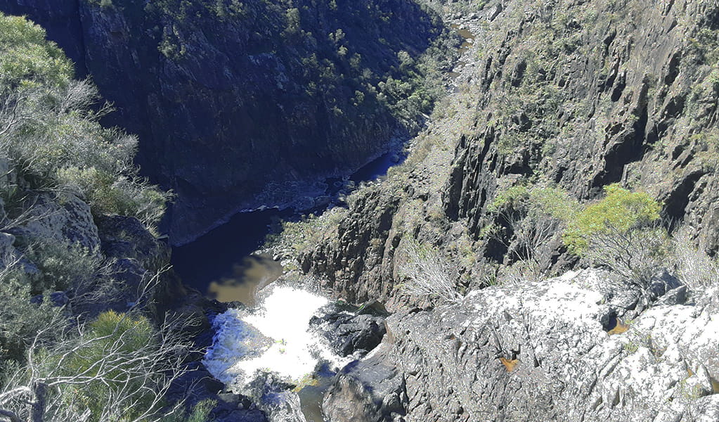 View of a waterfall cascading down a steep cliff into a deep gorge.  Photo credit: Josh Armitage &copy; DPIE