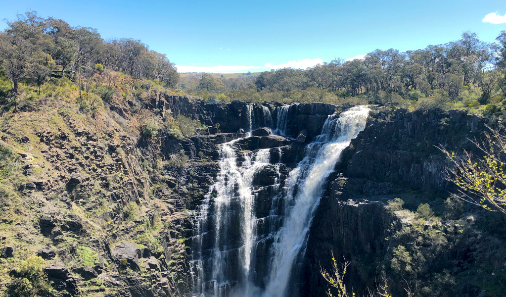 View of multiple cascades of water dropping off the top of a ridge and plummeting in steps down a cliff face.  Photo &copy; Jessica Stokes