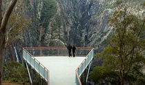 2 people view Wollomombi Falls from the wheelchair-accessible lookout platform in Oxley Wild Rivers National Park. Photo: Leah Pippos &copy; DPIE