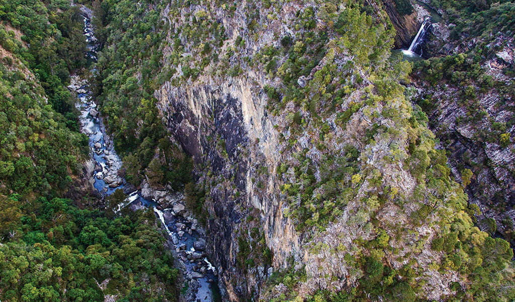Overhead view of a river and a waterfall set in a rugged landscape of deep canyons.  Photo &copy; Gerhard Koertner