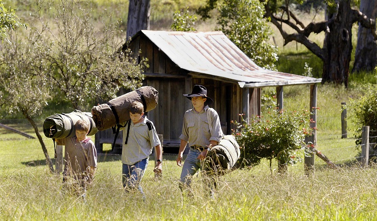 3 young boys carrying swags to Youdales Hut campground and picnic area. Photo: Paul Mathews