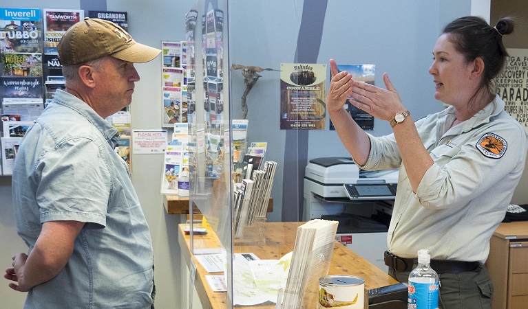 An NPWS worker gives advice to a visitor at the counter, Pilliga Forest Discovery Centre. Photo: Leah Pippos &copy; DPIE