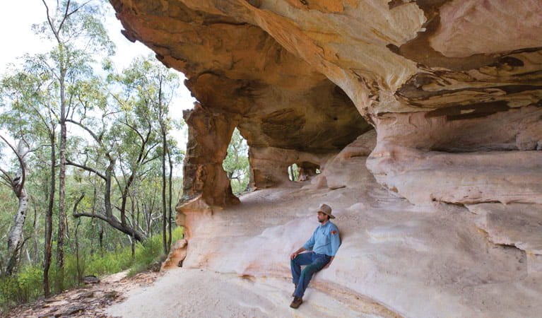 Man reclining on a Sandstone Cave. Photo: Rob Cleary