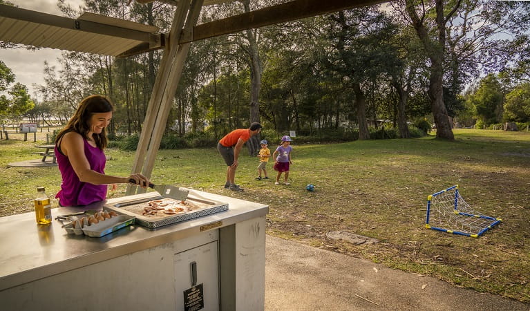 Family enjoying a barbecue lunch and a casual game of soccer. Photo: John Spencer/OEH