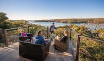 A family enjoying the view from the balcony of Hilltop Cottage in Royal National Park. Photo: John Spencer &copy; DPIE