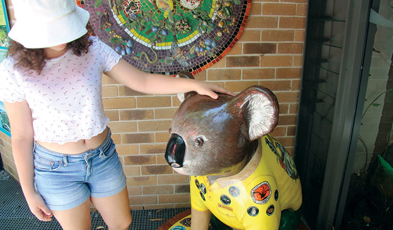 Girl next to a large koala sculpture wearing a NSW National Parks uniform. Credit: Natasha Webb. &copy; Natasha Webb/DPIE