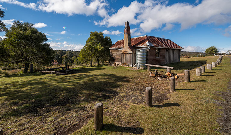 Alexanders Hut, with woodpile and barbecue area with benches for day use. Photo: John Spencer/OEH