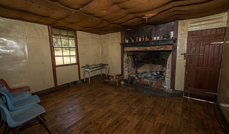 Interior of Alexanders Hut, showing fireplace, window and door. Photo: John Spencer/OEH