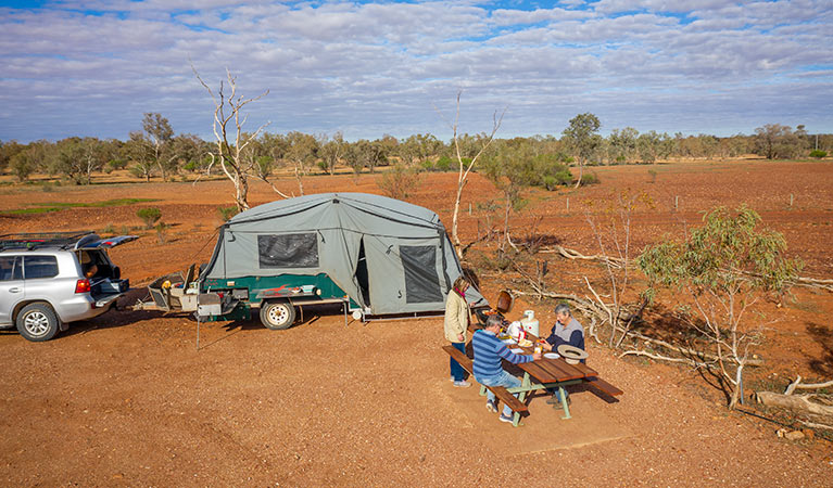 Campers eating breakfast next to their camper trailer at Mount Wood campground. Photo: John Spencer/DPIE