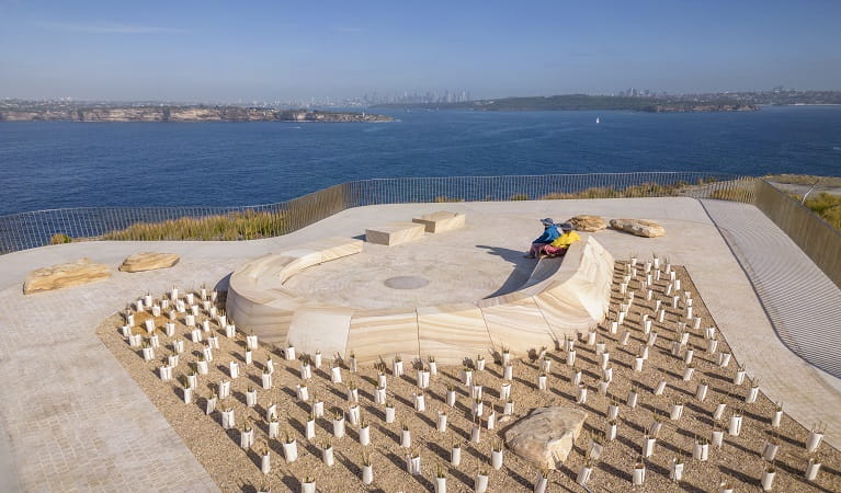 Visitors take in harbour views from the sandstone seating at Burragula lookout, Sydney Harbour National Park. Photo: John Spencer &copy; DPE