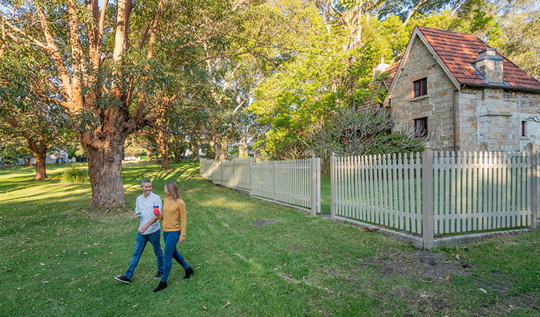 A couple walking out the front gate of Gardeners Cottage in Sydney Harbour National Park. Photo: John Spencer/DPIE
