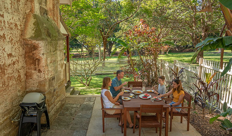 A family eating lunch in the courtyard of Gardeners Cottage in Sydney Harbour National Park. Photo: John Spencer/DPIE