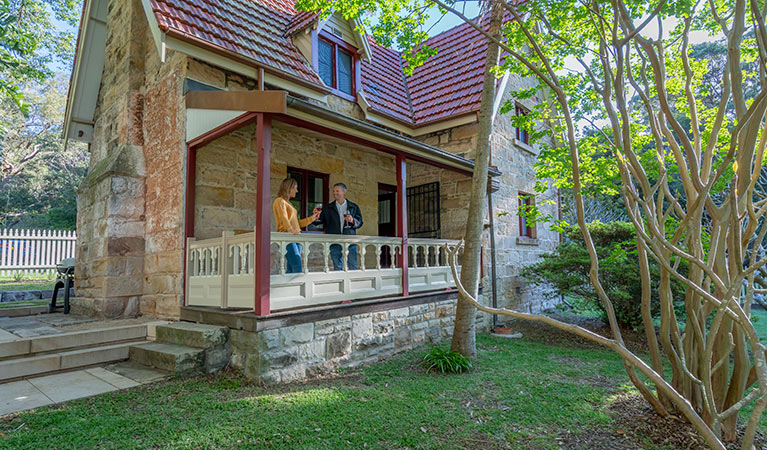 Two people on the verandah of Gardeners Cottage in Sydney Harbour National Park. Photo: John Spencer/DPIE